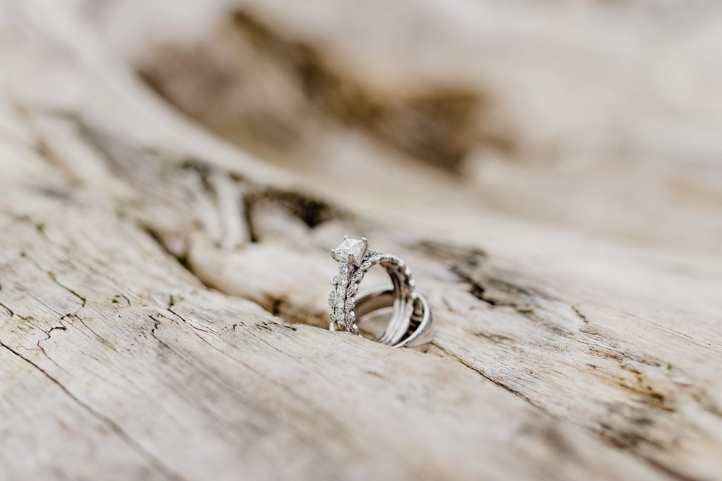 up close ring shot of wedding ring on driftwood