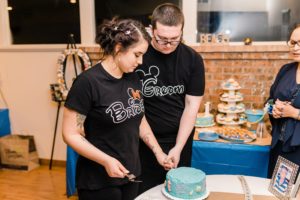 Bride and Groom in matching disney shirts cut wedding cake