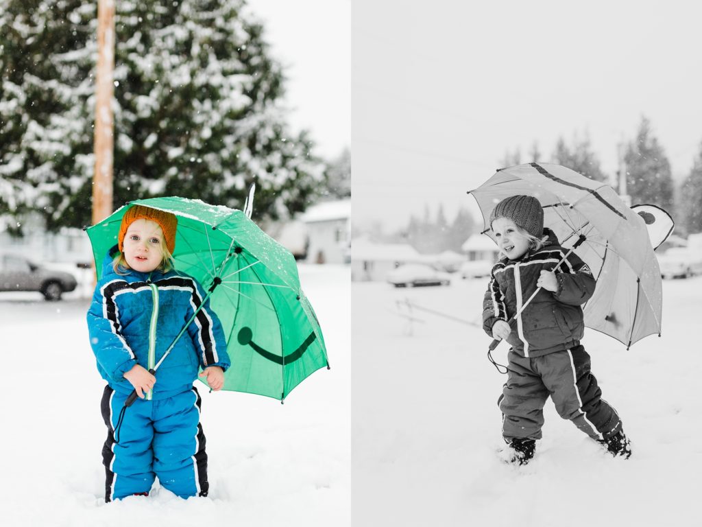 Two year old in blue snow suit with green umbrella