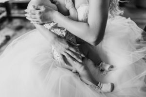 Breastfeeding Bride focus on brides arms wrapped around baby